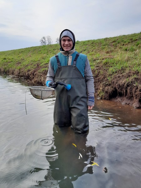 Junger Mann in Ausrüstung beim Forschungsarbeiten am Wasser.