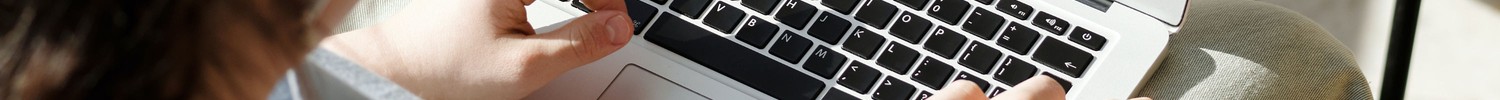 Hand tippt auf Laptop.